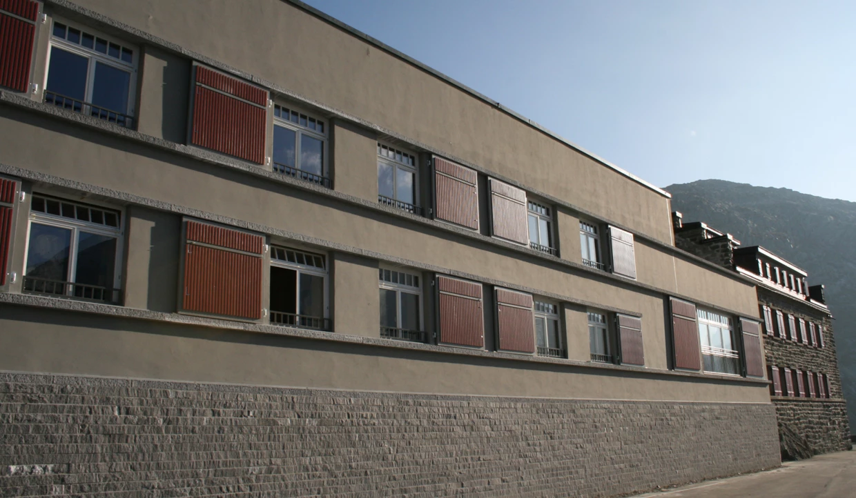 Außenansicht eines Gebäudes mit roten Fensterläden.