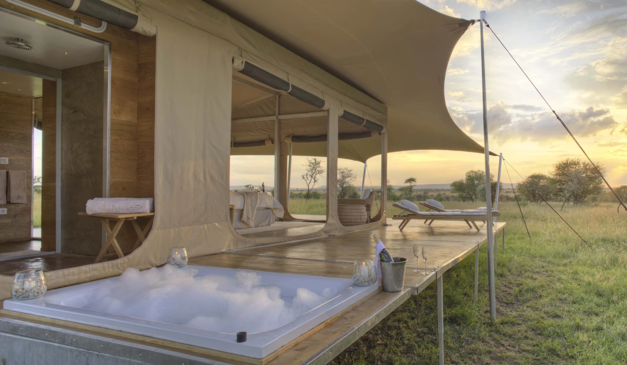 Außenbadewanne auf Terrasse eines Zeltes in Graslandschaft
