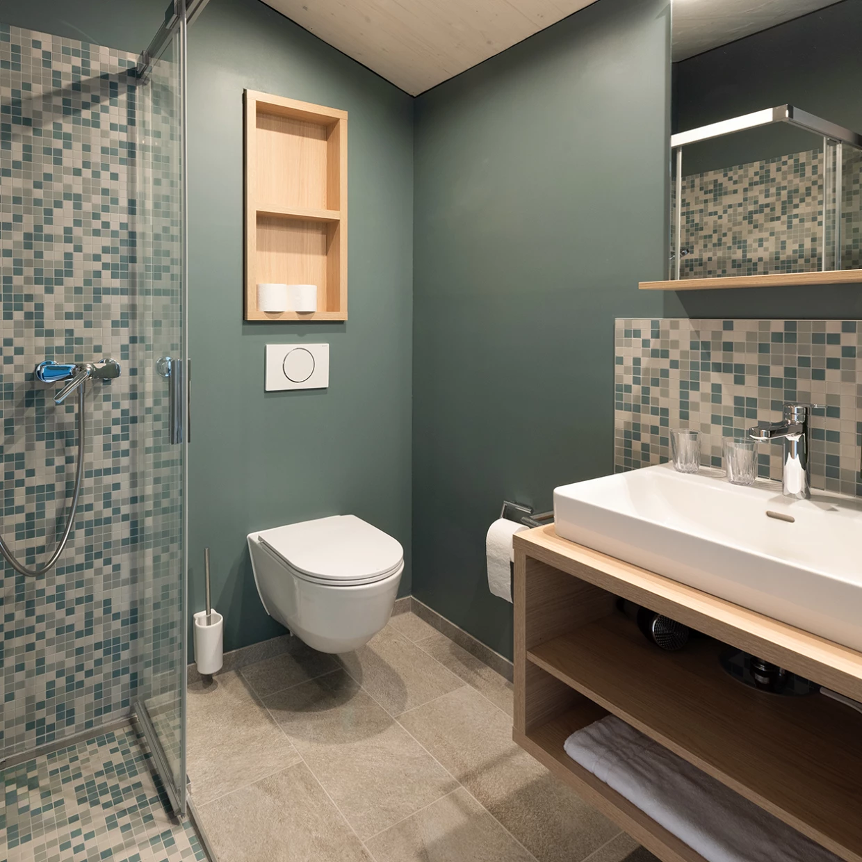 Badezimmer mit Duschkabine, blauen Mosaikfliesen und Waschbecken