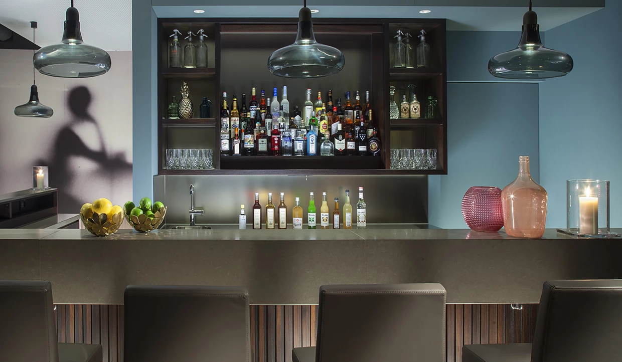 Bar mit Flaschen, Gläsern und Hängelampen