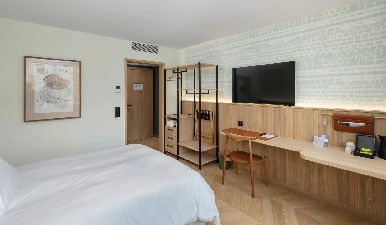 Hotelzimmer mit Kunstwerk, TV und modernem Schreibtisch