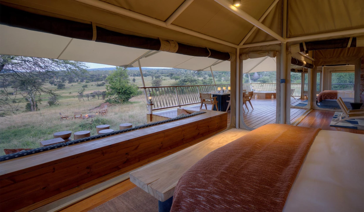 Blick aus einem luxuriösen Safari-Zelt auf die Terrasse und die Savanne