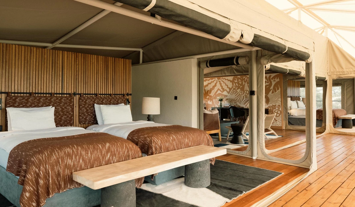 Luxuriöses Zeltinterieur mit zwei Betten und Holzlamellenwand