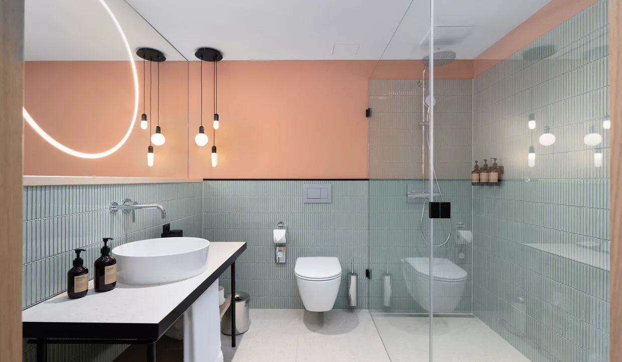 Modernes Badezimmer mit Glasdusche und hängenden Lichtern