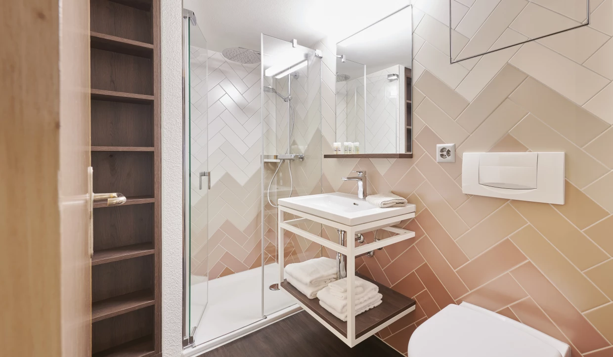 Modernes Badezimmer mit Glasdusche und weißem Waschbecken