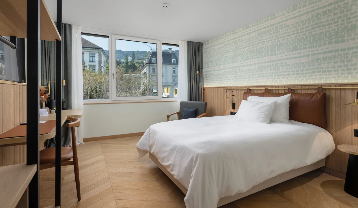 Modernes Hotelzimmer mit Doppelbett und großem Fenster