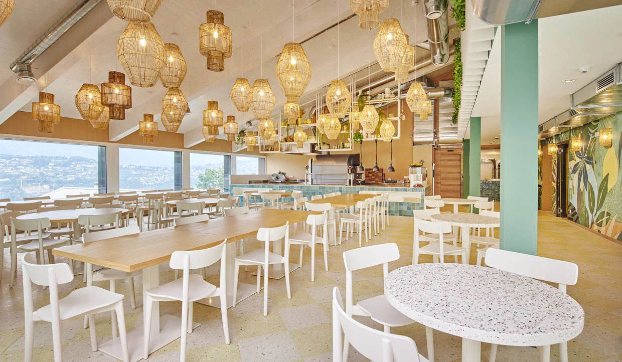 View of restaurant area with large windows, tables, and chairs