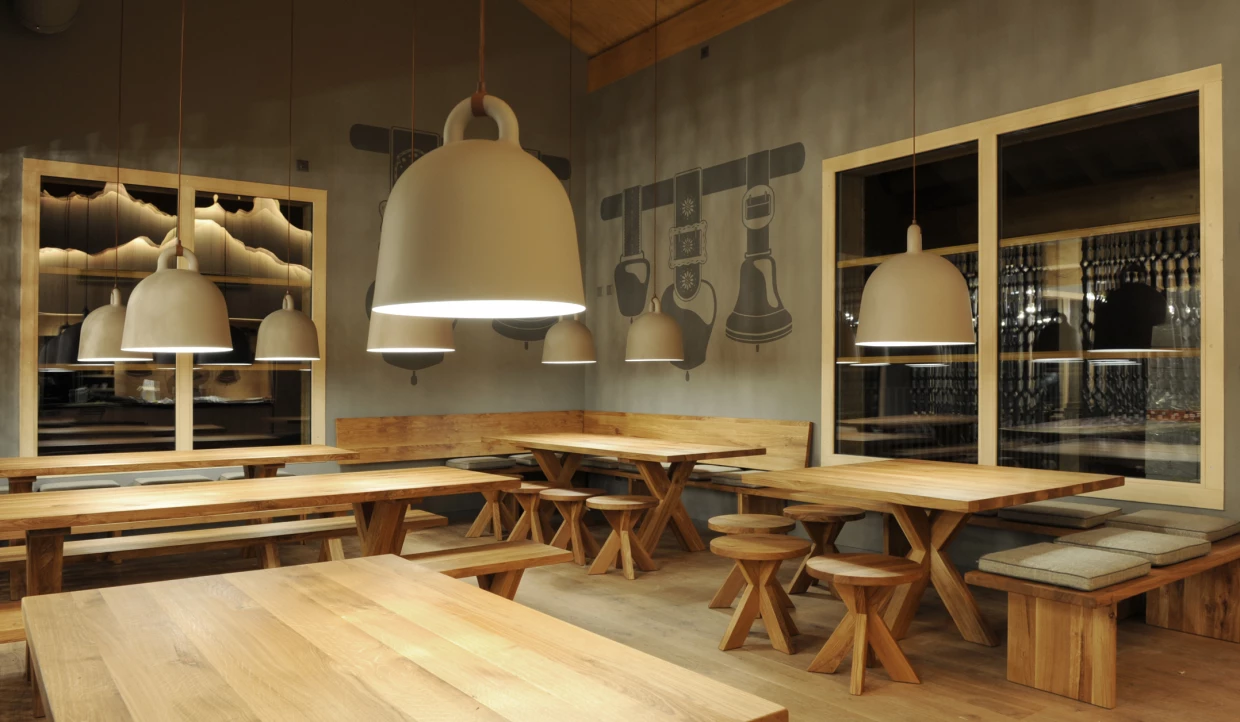Dining area with wooden tables and large pendant lamps
