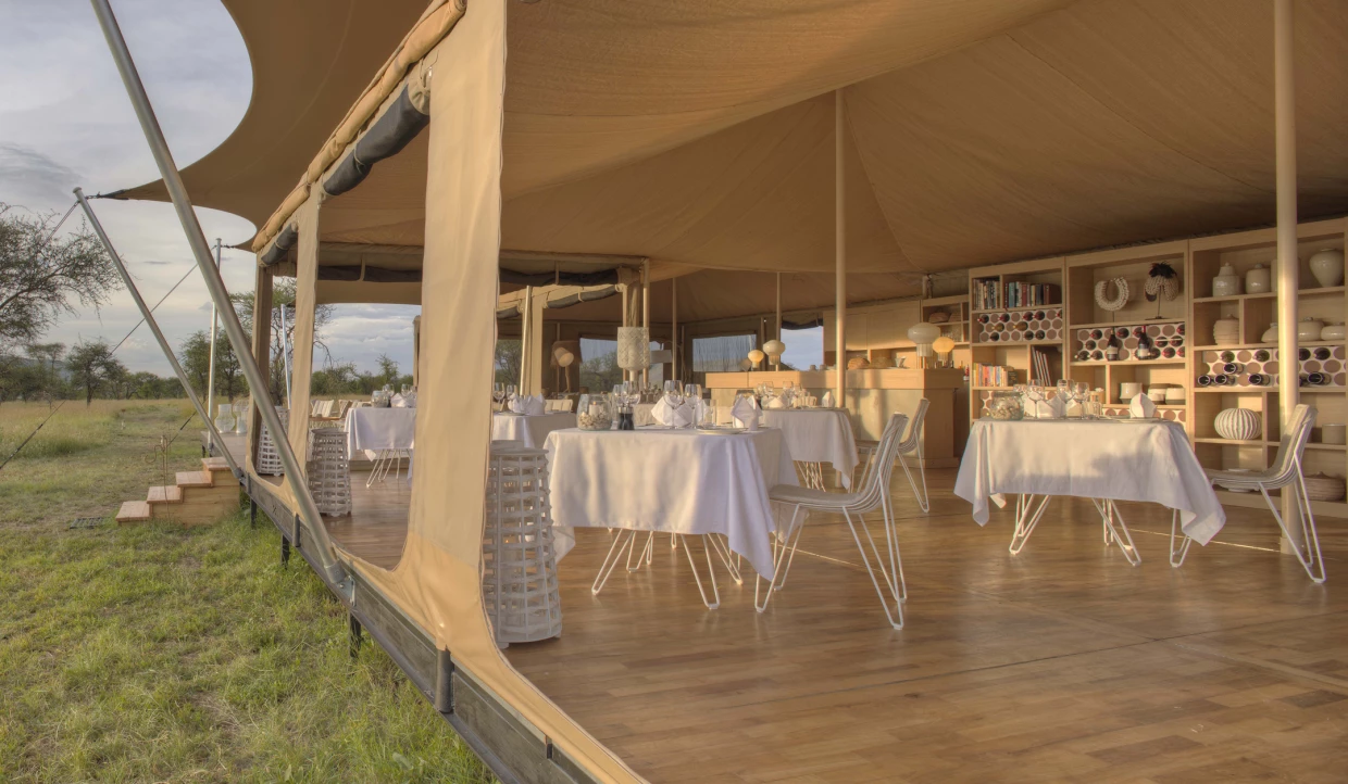 Dining area under tent with tables and white tablecloths