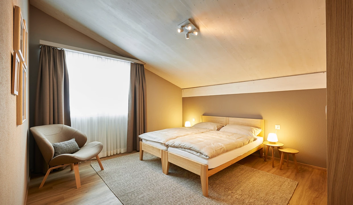 Schlafzimmer mit Doppelbett und Sessel