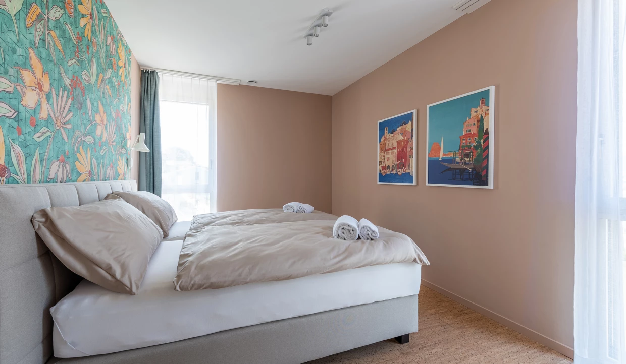 Schlafzimmer mit floralem Wanddesign und zwei gerahmten Bildern