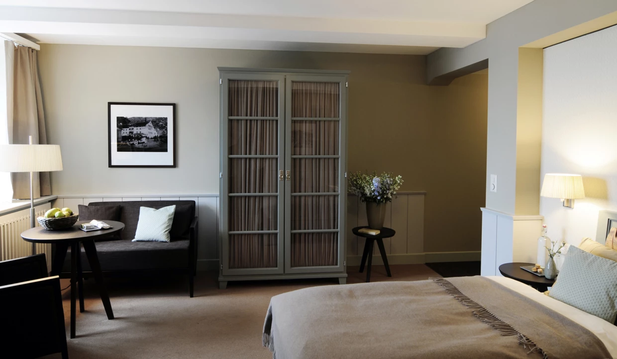 Schlafzimmer mit Sofa, Tisch und großem Schrank.