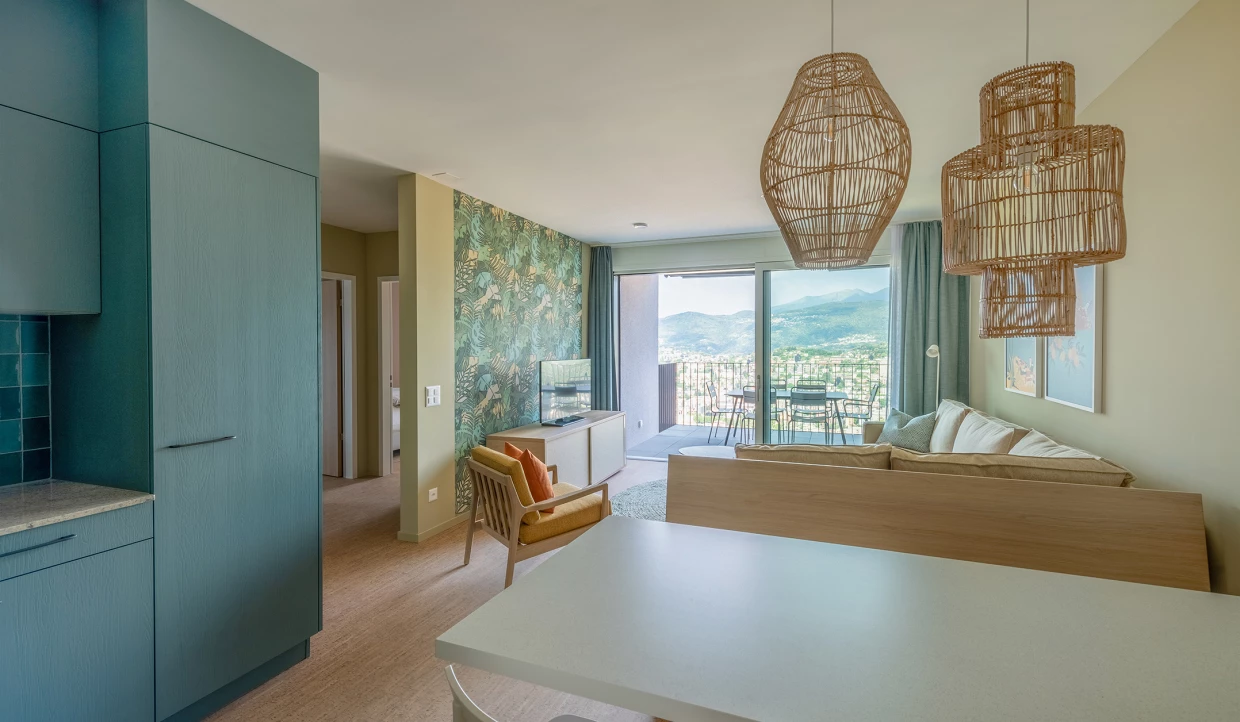 Wohnbereich mit Sofa, Rattandeckenleuchten und Bergblick