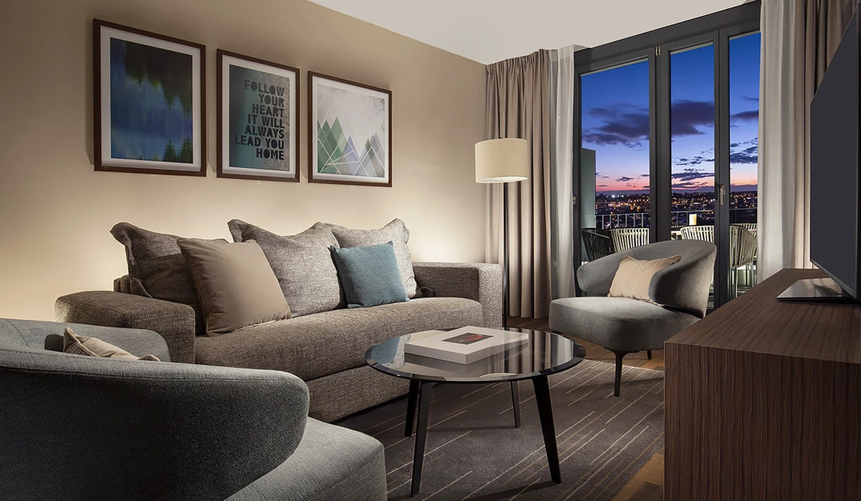 Wohnzimmer mit Sofa, Kunst an der Wand und Abendblick