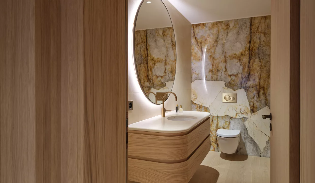 Bathroom with oval mirror and marble wall