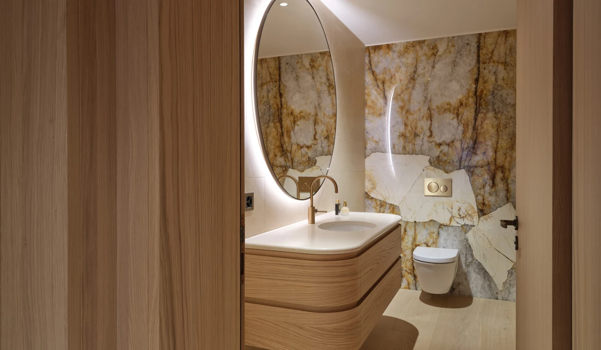 Bathroom with oval mirror and marble wall