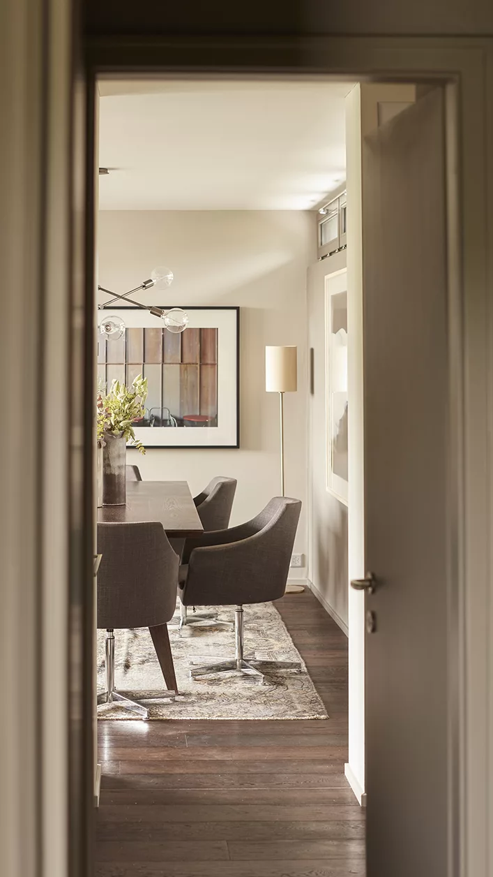 Blick durch die Tür auf modernes Esszimmer mit Stühlen und Gemälde