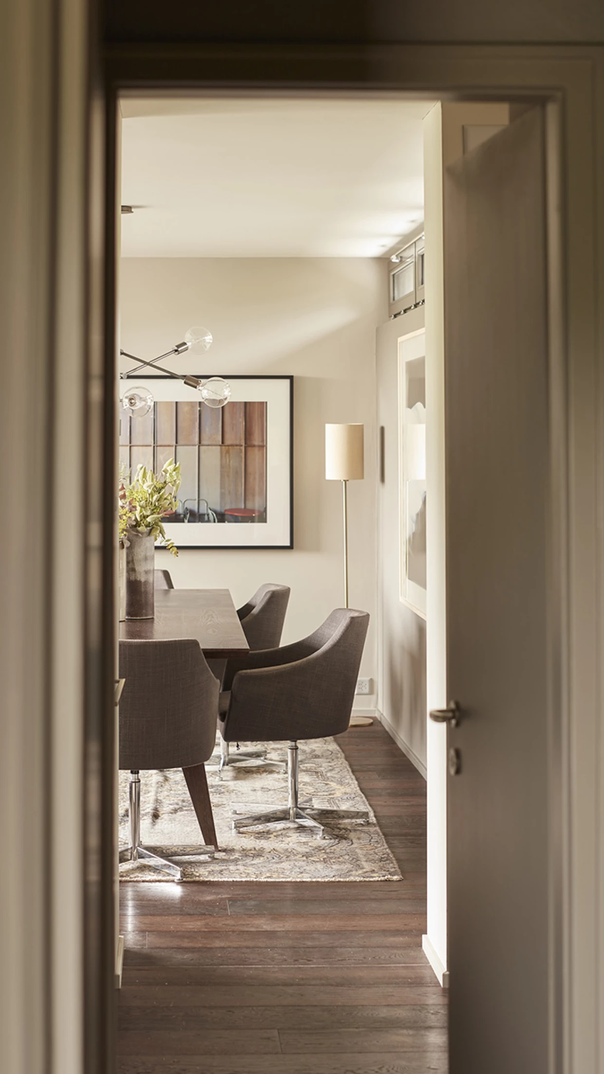 View through the door into a modern dining room with chairs and painting