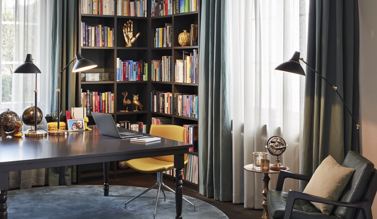 Büro mit Bücherregalen, Tischlampe und Stuhl