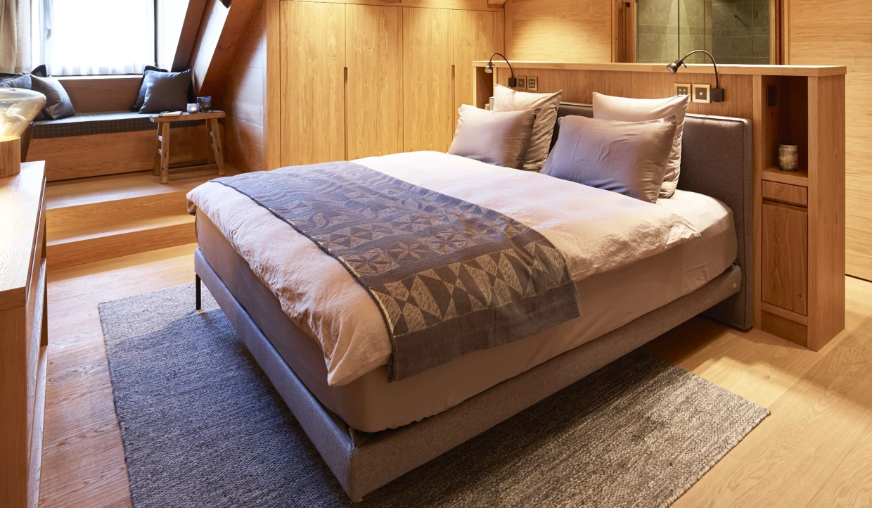 Gemütliches Schlafzimmer mit Fenster und Holzverkleidung