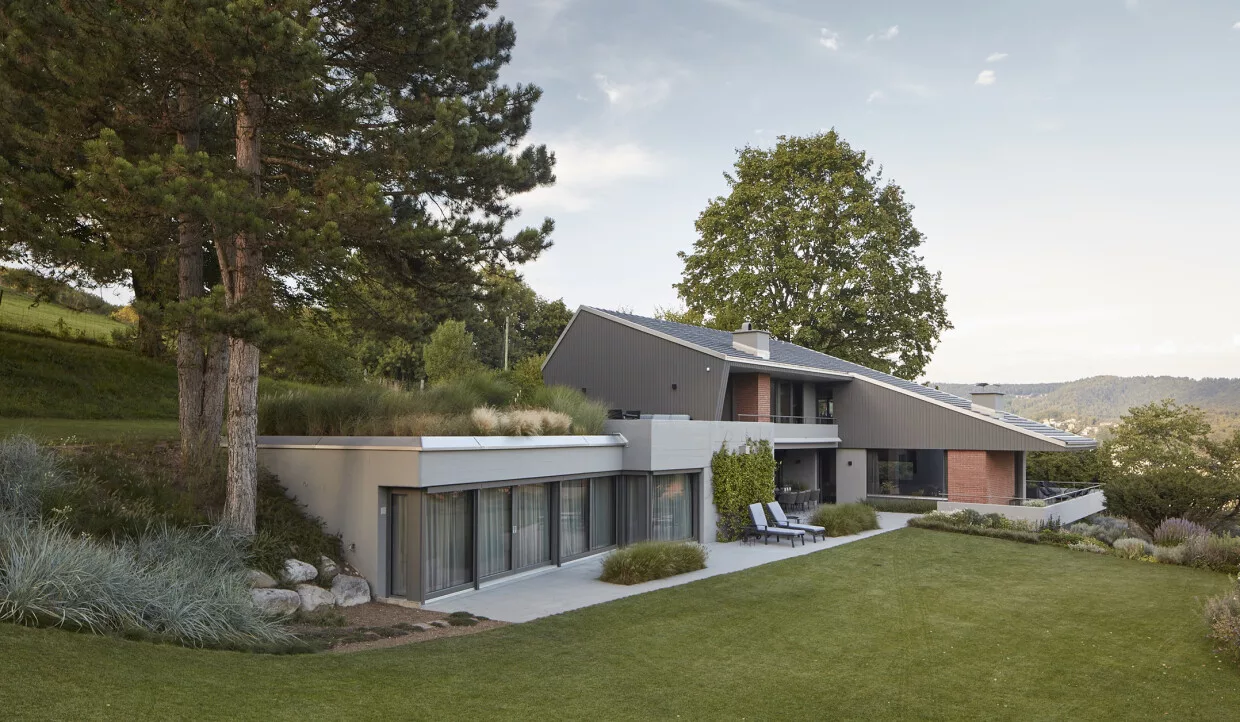 Modernes Haus mit begrüntem Dach und großen Fenstern in natürlicher Umgebung