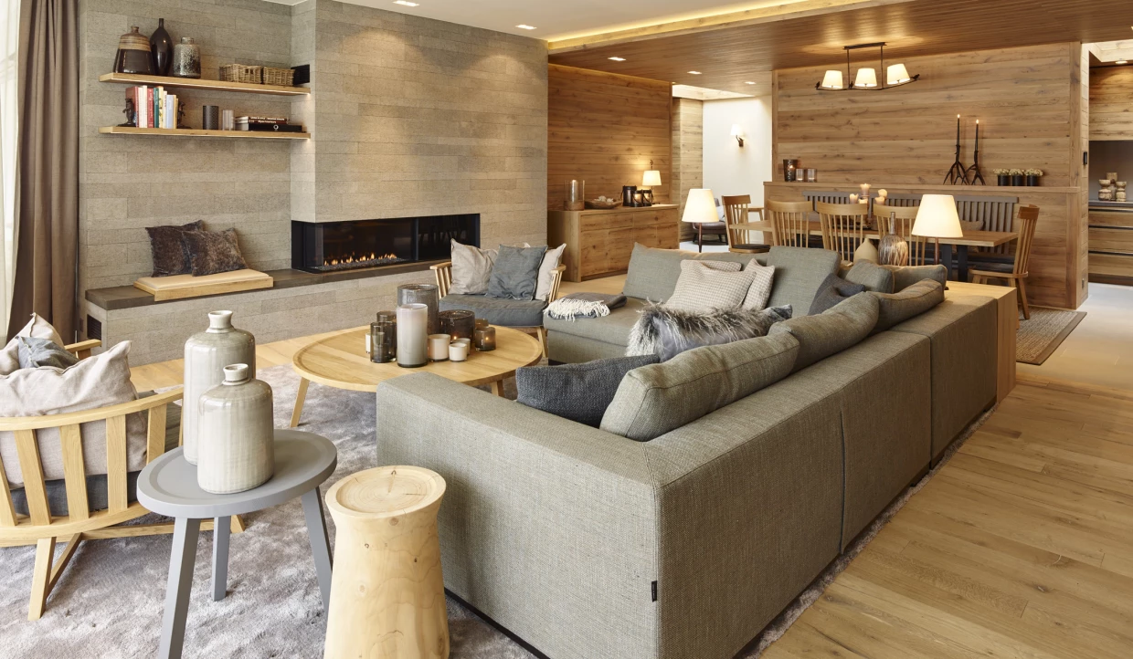 Modernes Wohnzimmer mit grauem Sofa, Holzmöbeln und Kamin