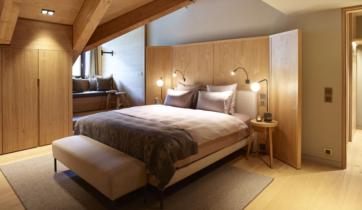 Schlafzimmer mit Bett, Holzwänden und Decken