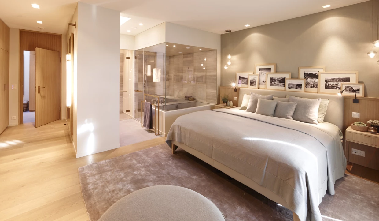 Schlafzimmer mit großem Doppelbett und Glasdusche