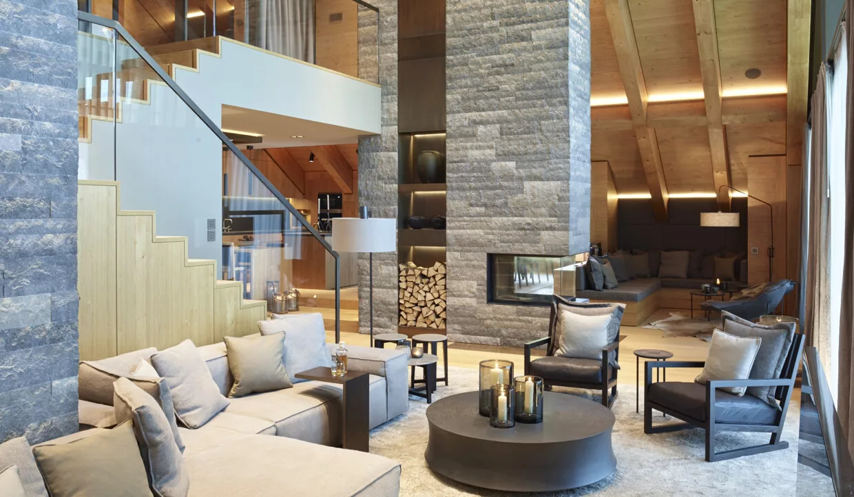 Living area with fireplace, wood paneling and stairs