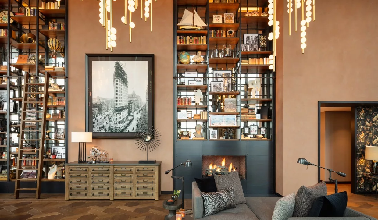 Wohnzimmer mit großer Bücherwand und Kamin