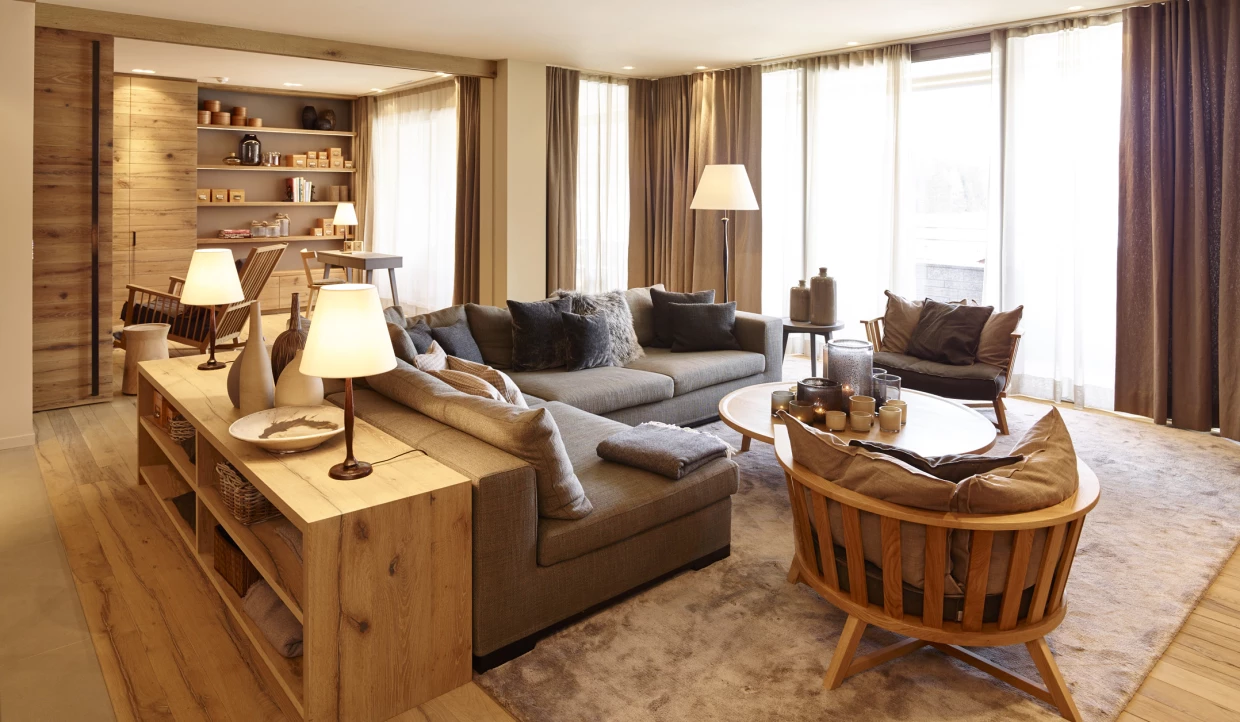 Wohnzimmer mit großen Fenstern, Holzmöbeln und Stehlampe