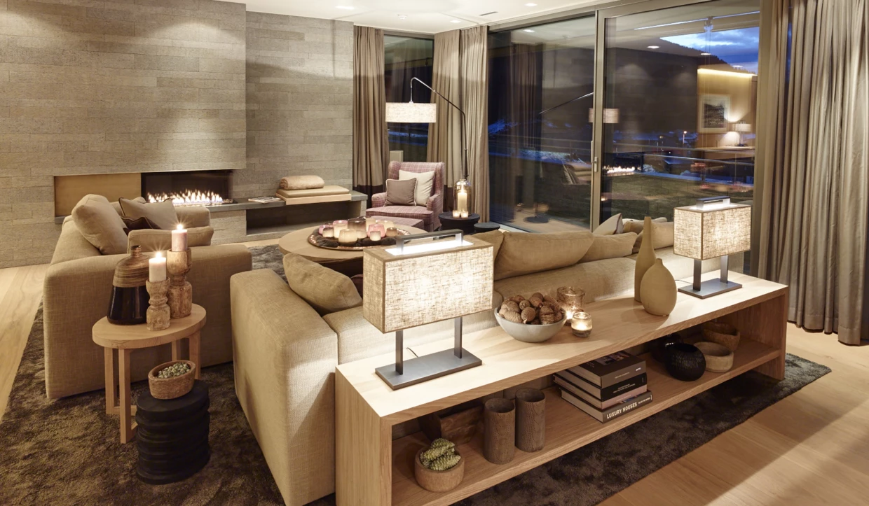 Wohnzimmer mit Sofa, Kamin und Glasfront