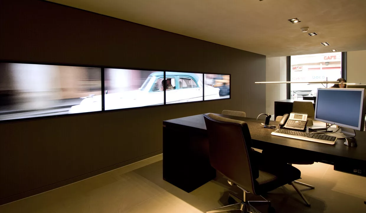 Workspace with computers, phones, and a large screen