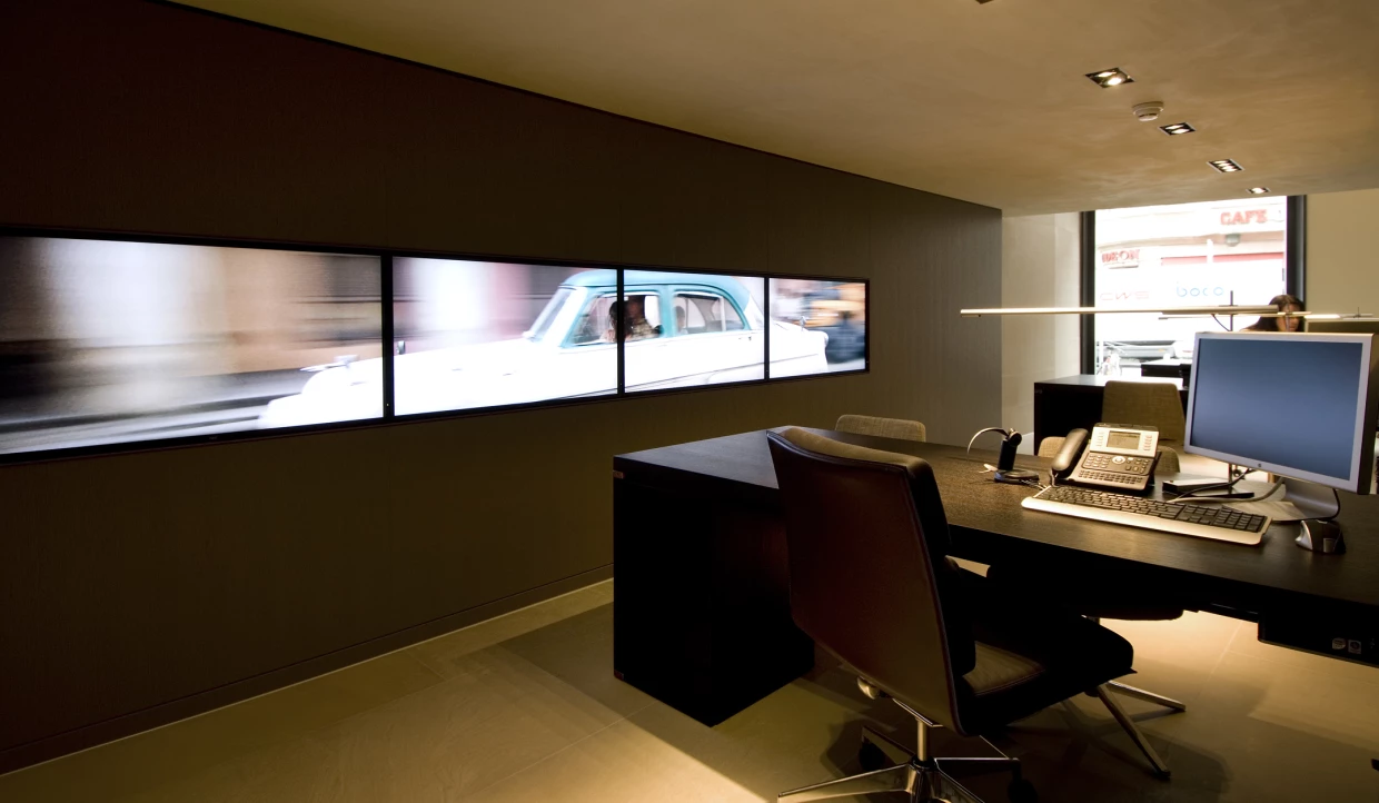 Workspace with computers, phones, and a large screen