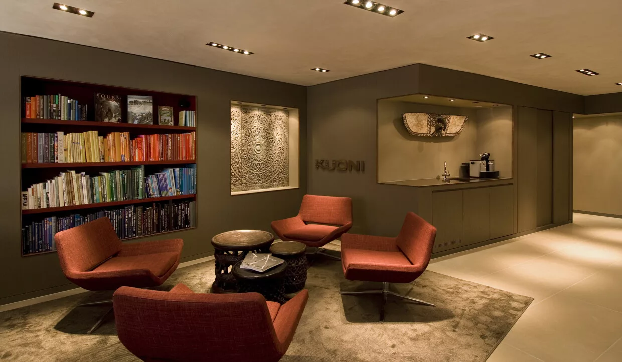 Elegant room with bookshelf, red chairs, and side tables