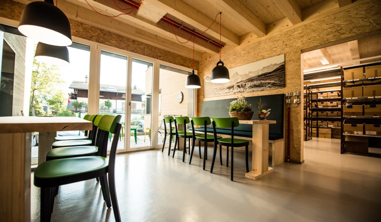 Dining area with green chairs and large windows