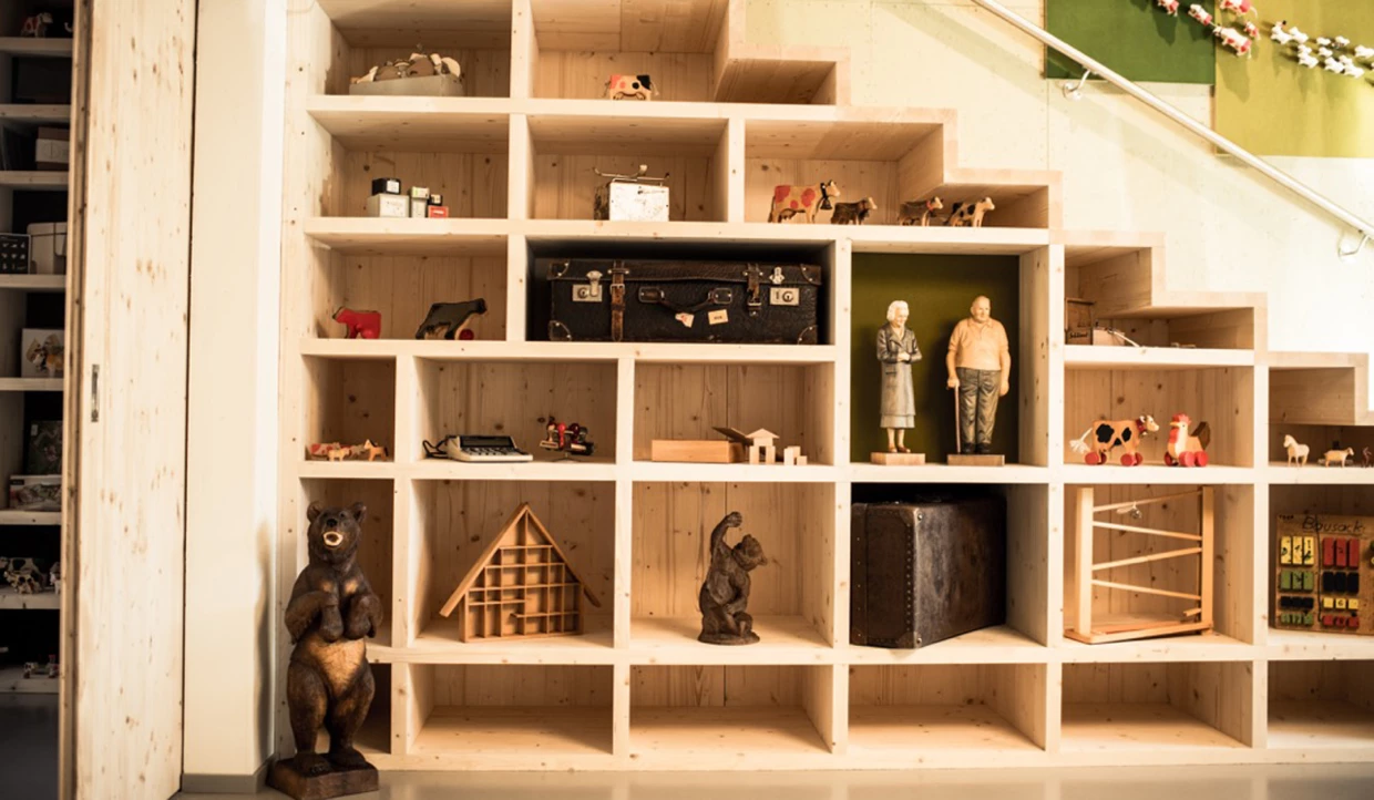 Wooden shelf with various figures and a suitcase
