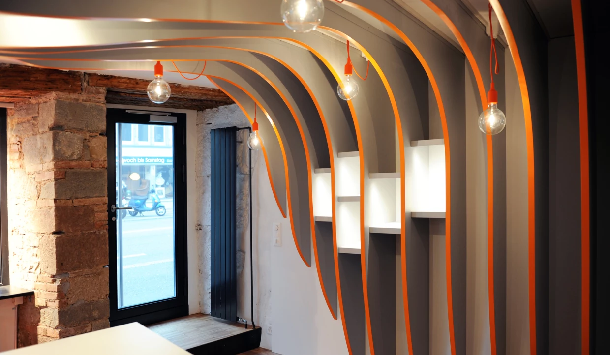 Laden-Interieur mit gebogenen Wänden und hängenden Glühbirnen