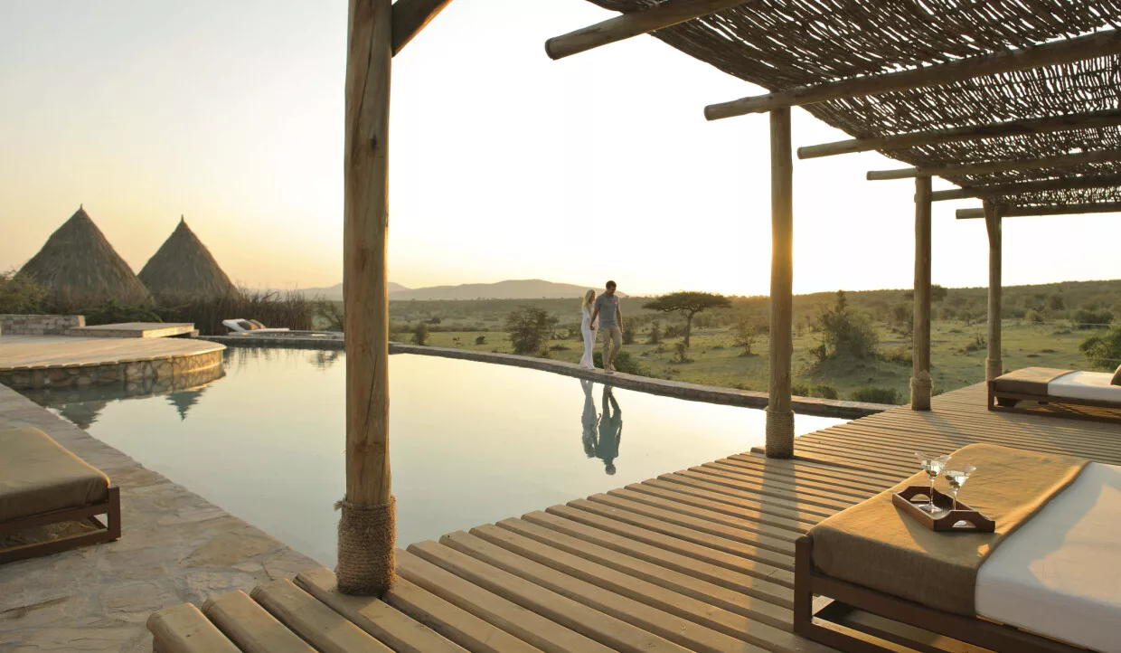 Blick von der Terrasse einer Luxus-Safari-Lodge mit Liegen über den Pool