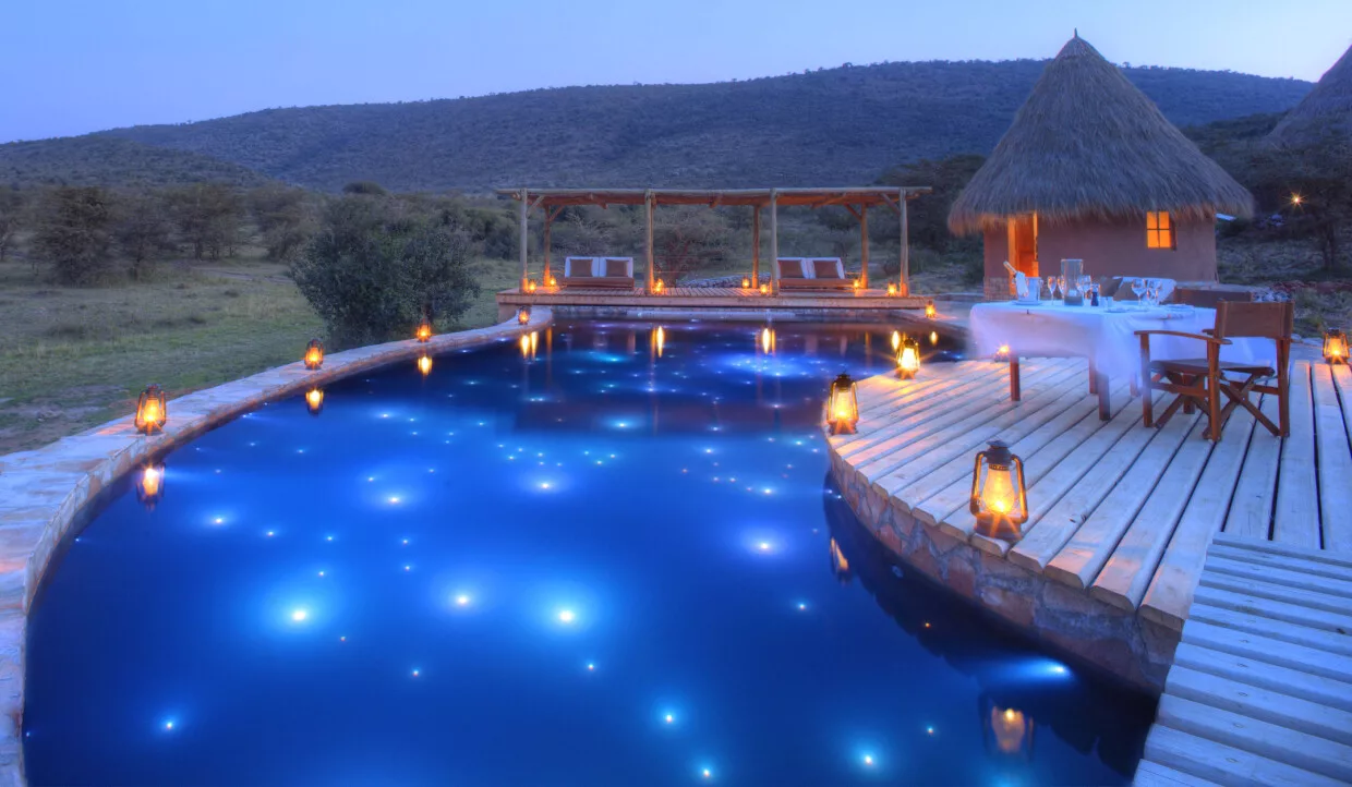 Stimmungsvoller Pool mit Laternen in der Nacht.